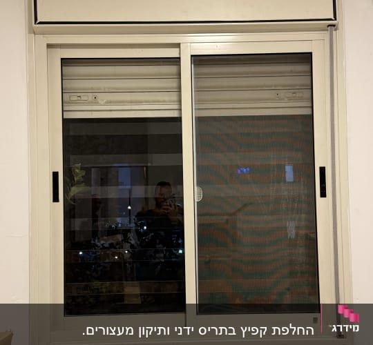 חלון עם תריסים סגורים ומסגרת לבנה